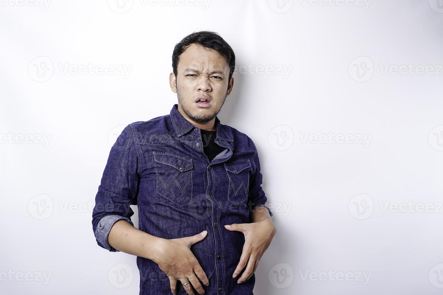 A portrait of insecure Asian fat man is holding the fat on his belly photo