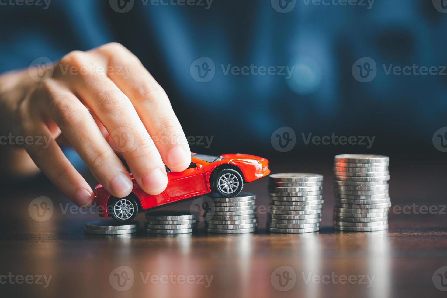 concepto de negocio de seguros de automóviles, compra de ahorro - venta con impuestos y préstamo para automóviles nuevos. vehículo de juguete de coche con dinero de moneda de pila en el fondo. planificación para administrar los costos de financiación del transporte. préstamo para coche foto