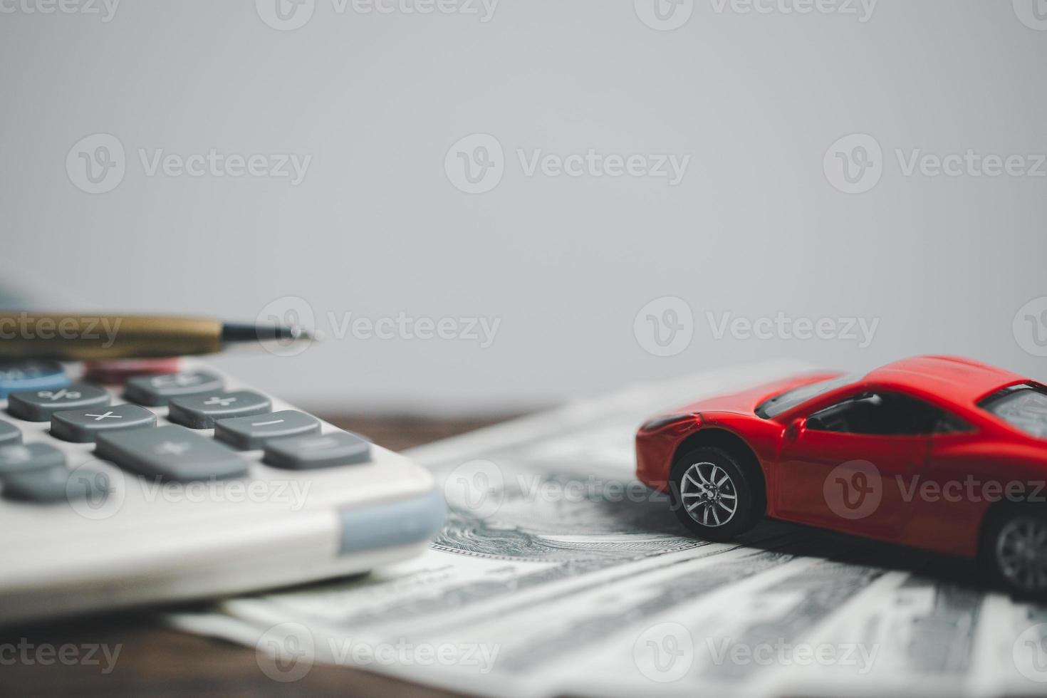 concepto de negocio de seguros de automóviles, compra de ahorro - venta con impuestos y préstamo para automóviles nuevos. vehículo de juguete de coche con dinero de moneda de pila en el fondo. planificación para administrar los costos de financiación del transporte. préstamo para coche foto