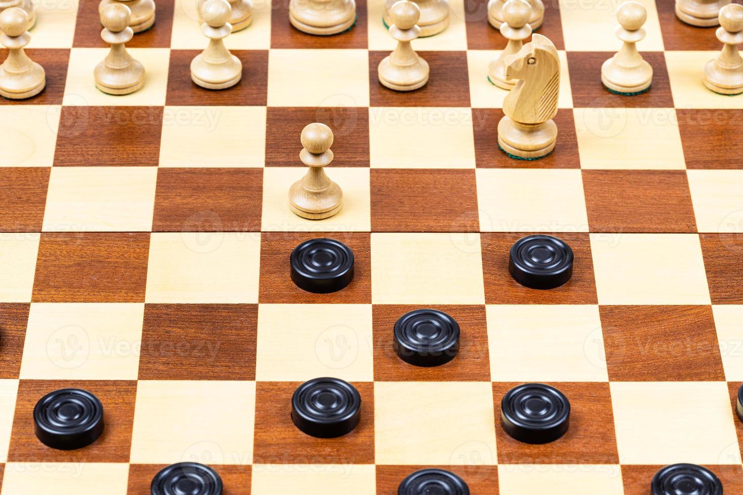 beginning of chess - checkers game on wood board photo