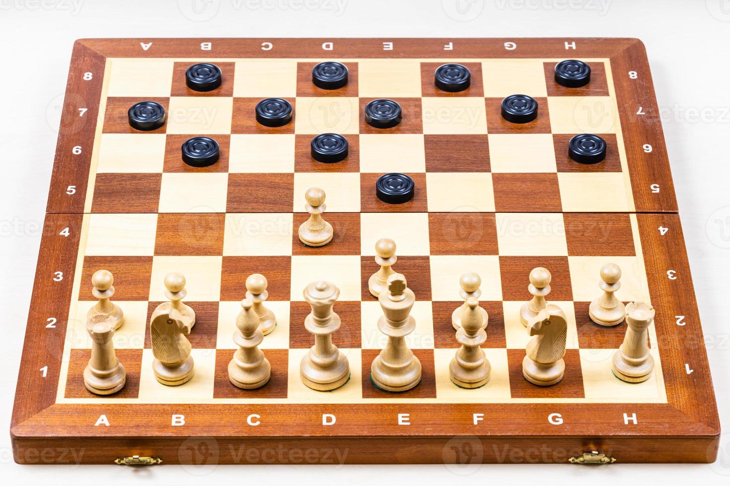 chessboard with first moves of chess and checkers photo