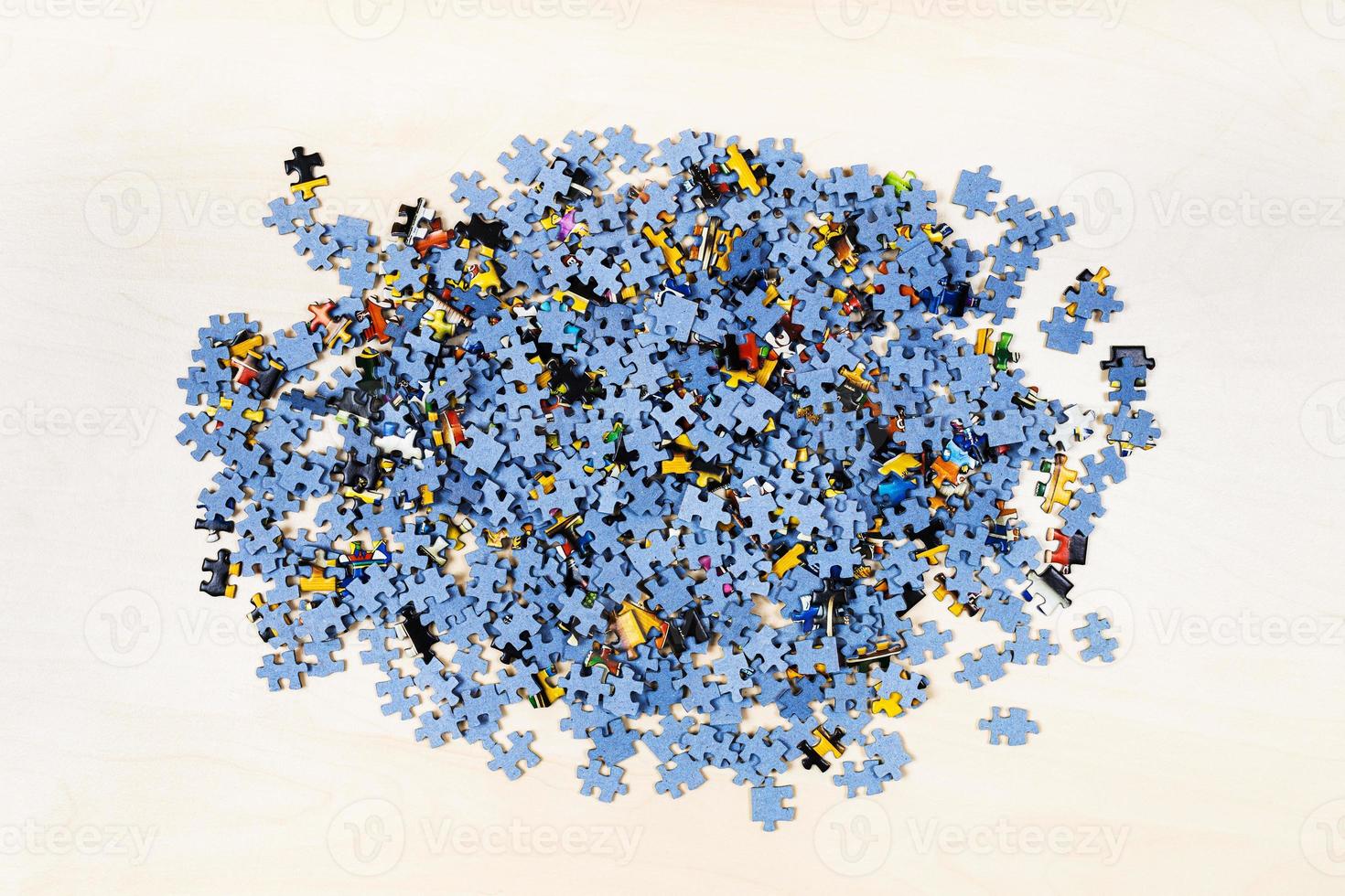 top view of pile of puzzle pieces on table photo