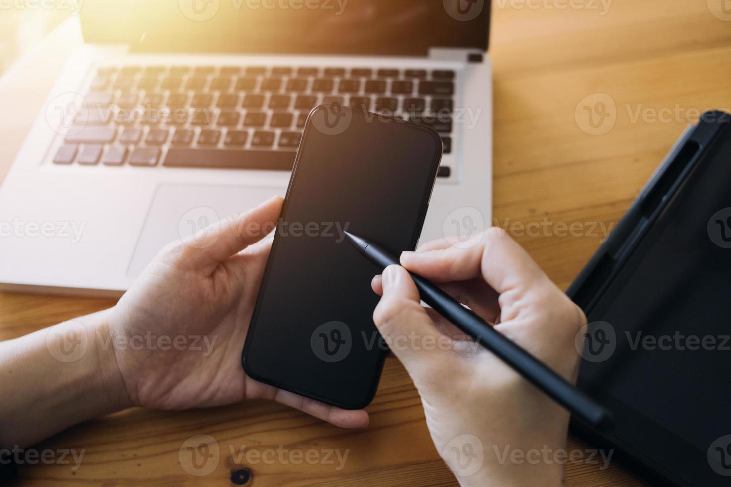 cerrar manos hombre multitarea usando tableta, computadora portátil y teléfono celular conectando wifi foto