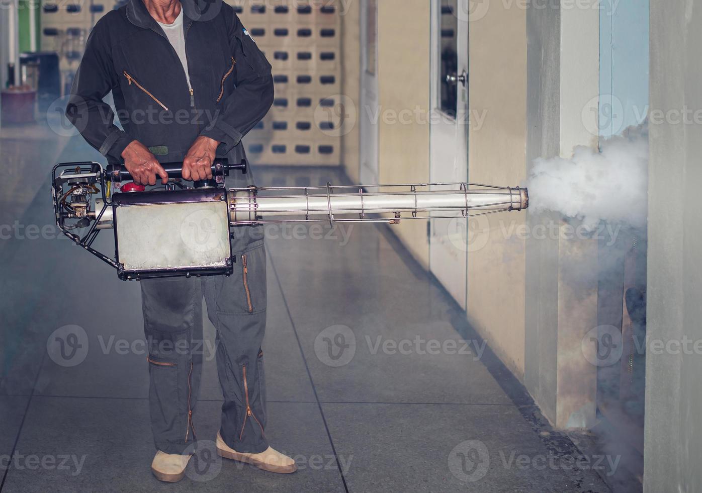 hombre rociando niebla, eliminando mosquitos, deteniendo la propagación del dengue foto