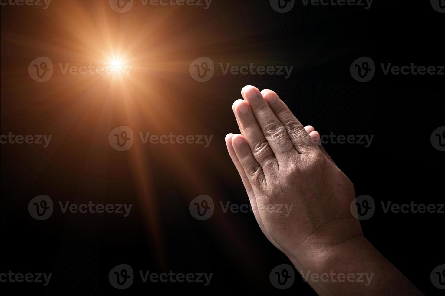 Hands folded in prayer on in church concept for faith, spirituality and religion, man praying in the morning. man hand with praying god. Person Christian men who have faith in Jesus worship in dark. photo