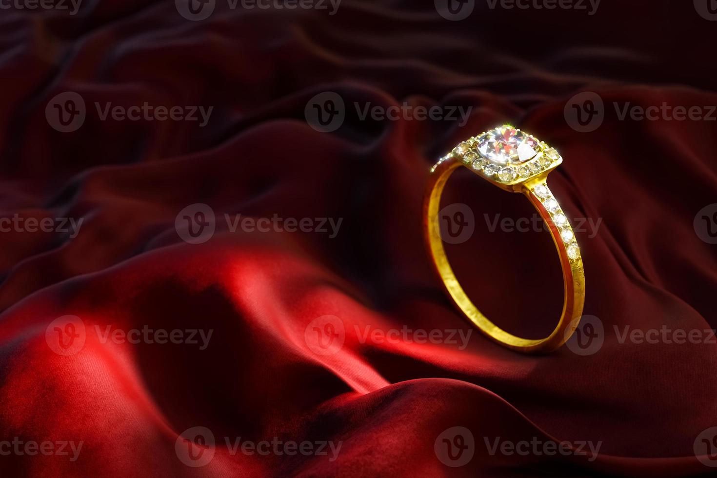 un anillo de oro y diamantes sobre terciopelo rojo. foto