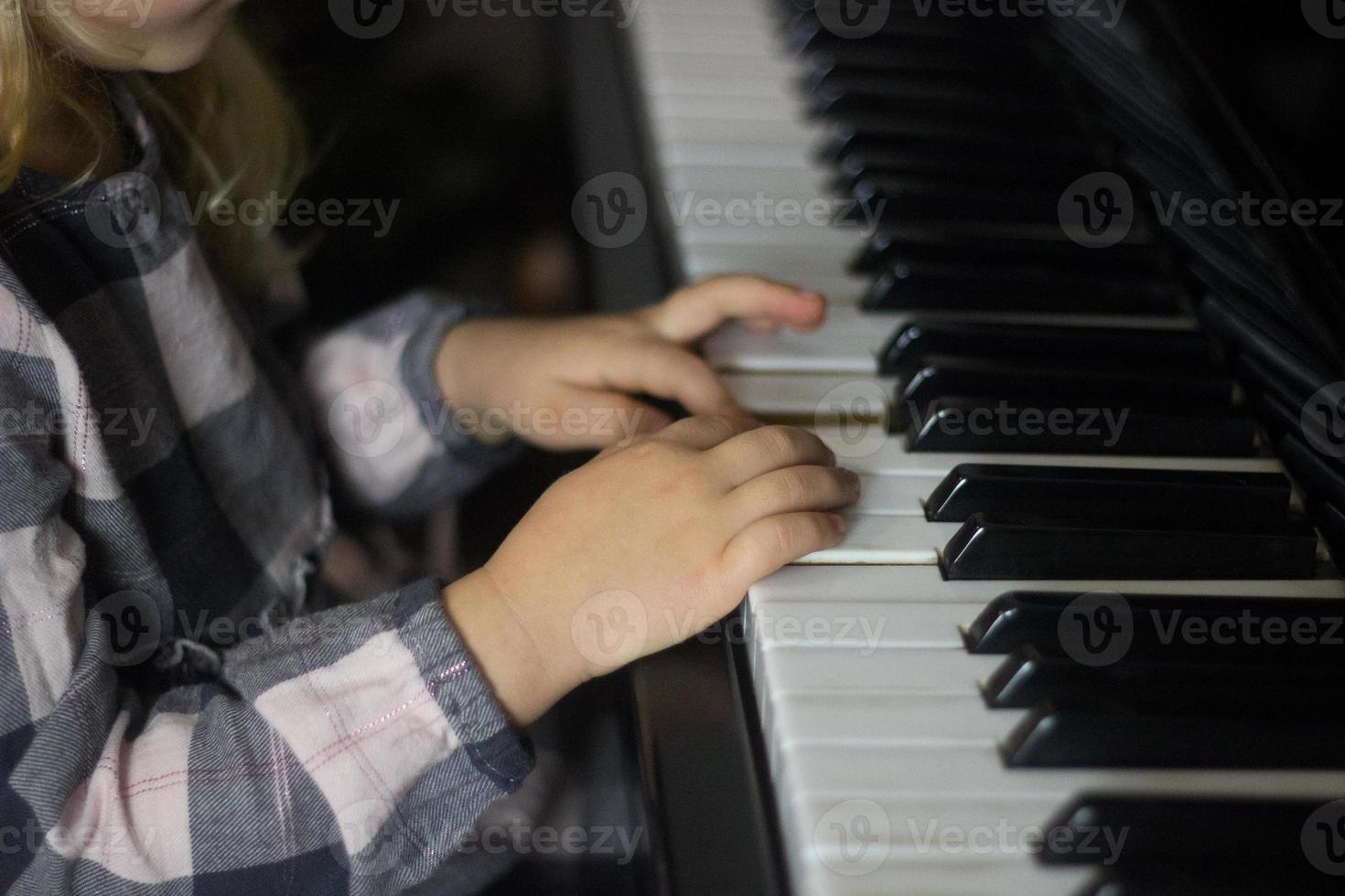 Little girl play piano,kids hands on piano keyboard close up,homeschooling,musical education.Growing talented child.Daily routine for toddler,side view of childs hands and piano photo