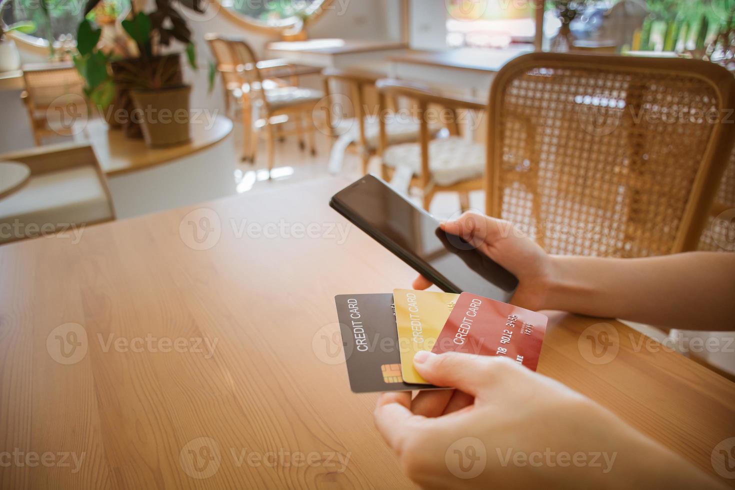 Close up female hands holding smart phone with credit card and choosing to use. using cellphone for digital banking, internet payment, online shopping, financial technology, E-commerce concept. photo