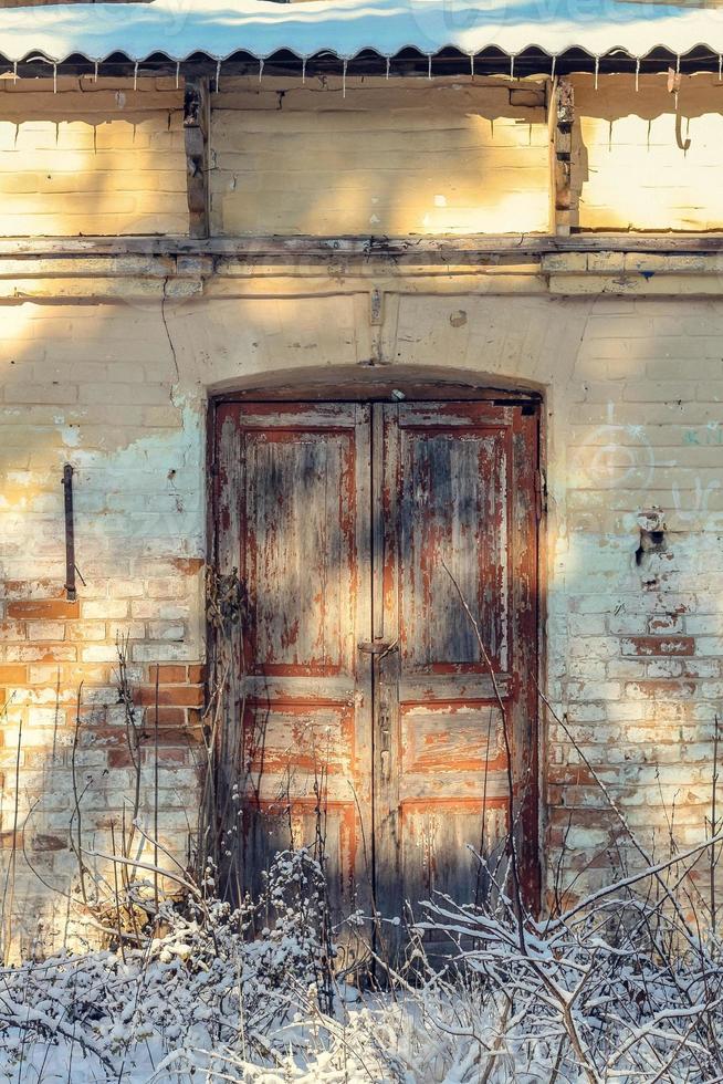 cerrar la vieja puerta descascarada de la pintura exterior del edificio abandonado concepto foto