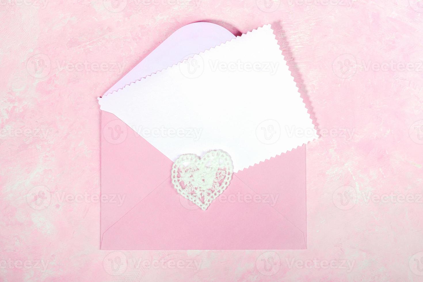 Pink envelope with lace heart and empty white blank sheet for text on pink. Top view. Close up. photo