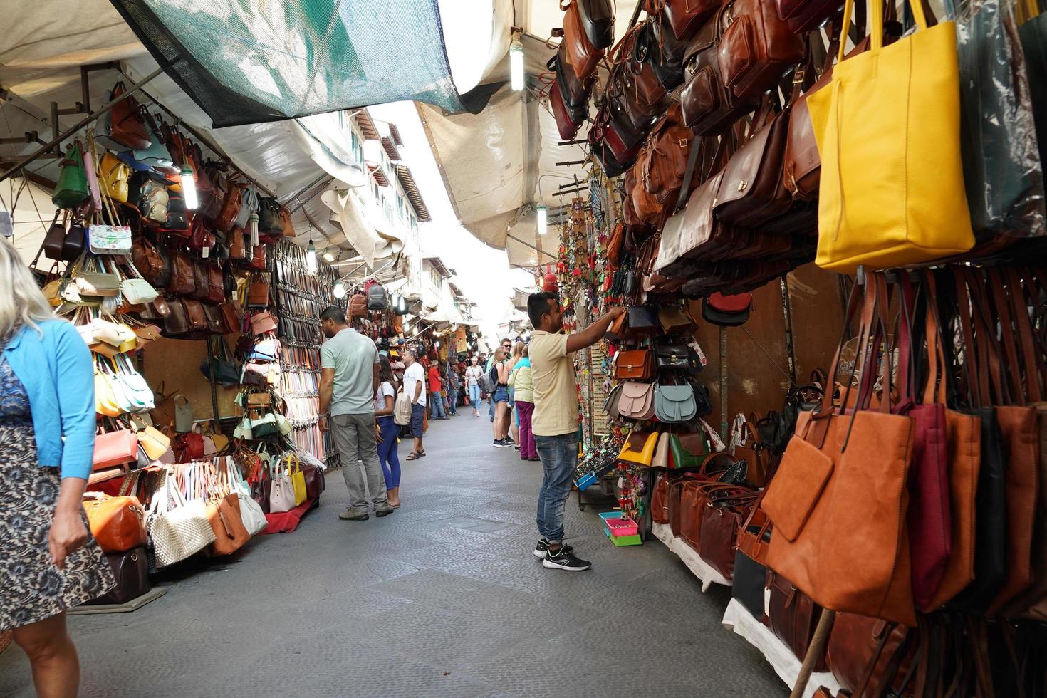 florencia, italia - 1 de septiembre de 2018 - gente comprando en el mercado de cuero de la ciudad vieja foto