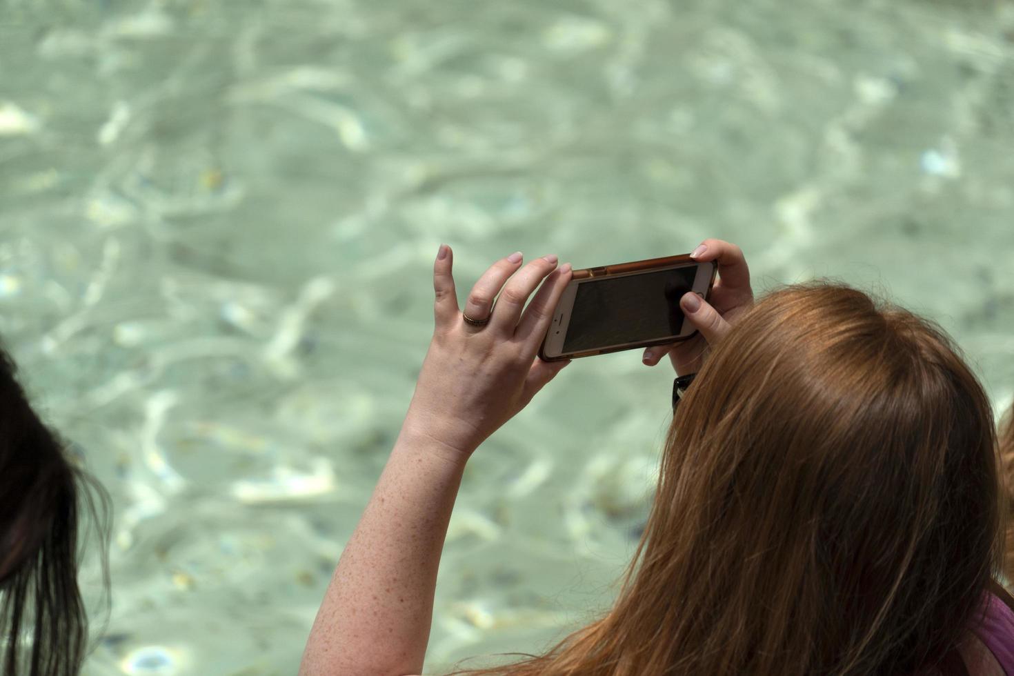 ROME, ITALY - JUNE 15 2019 - Tourist taking selfie at Fontana di Trevi fountain photo