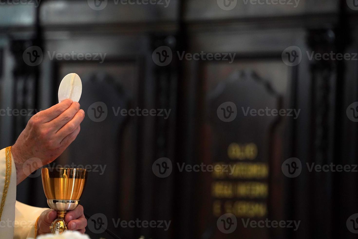 Priest showing the host during the mass photo