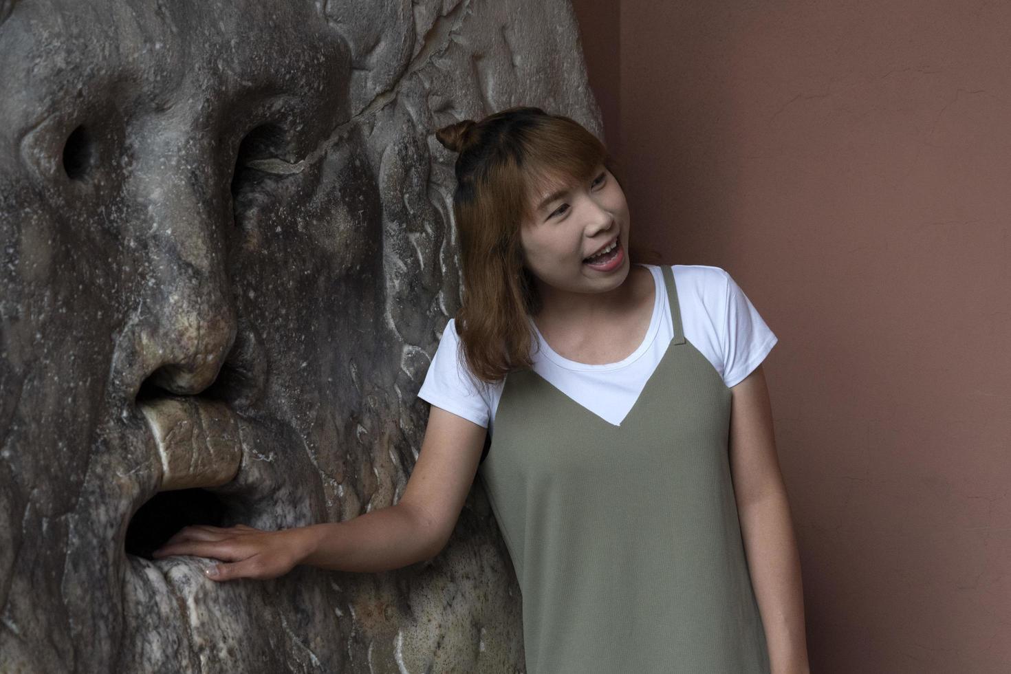 ROME, ITALY - JUNE 15 2019 - Tourist testing the mouth of truth mask photo