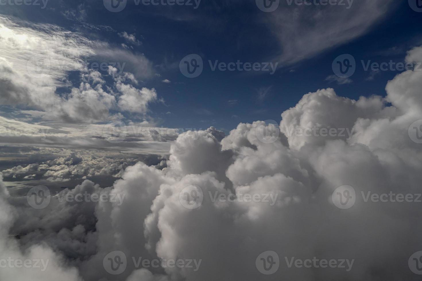 cloudy sky from airplane window while flying photo