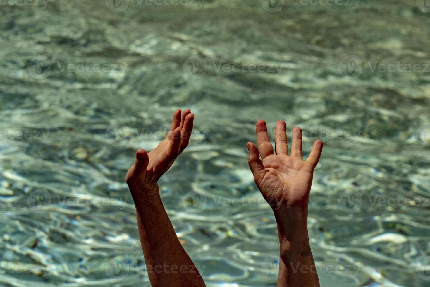 hands of black Migrant detail on boat asking for help from the sea background photo