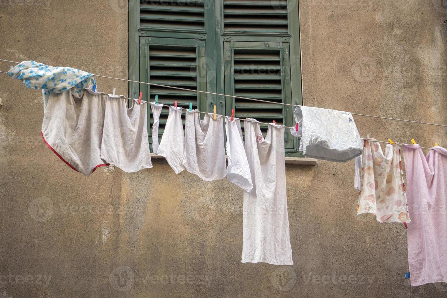 clothes hanging outside house drying to the sun photo