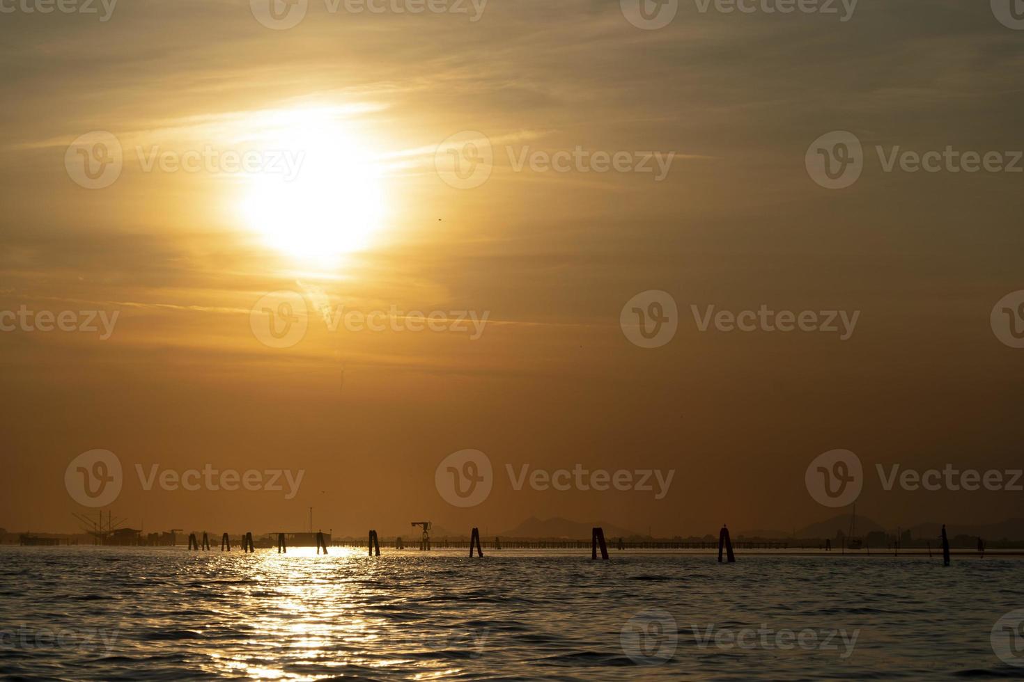 Sunset in Venice lagoon chioggia harbor from a boat photo