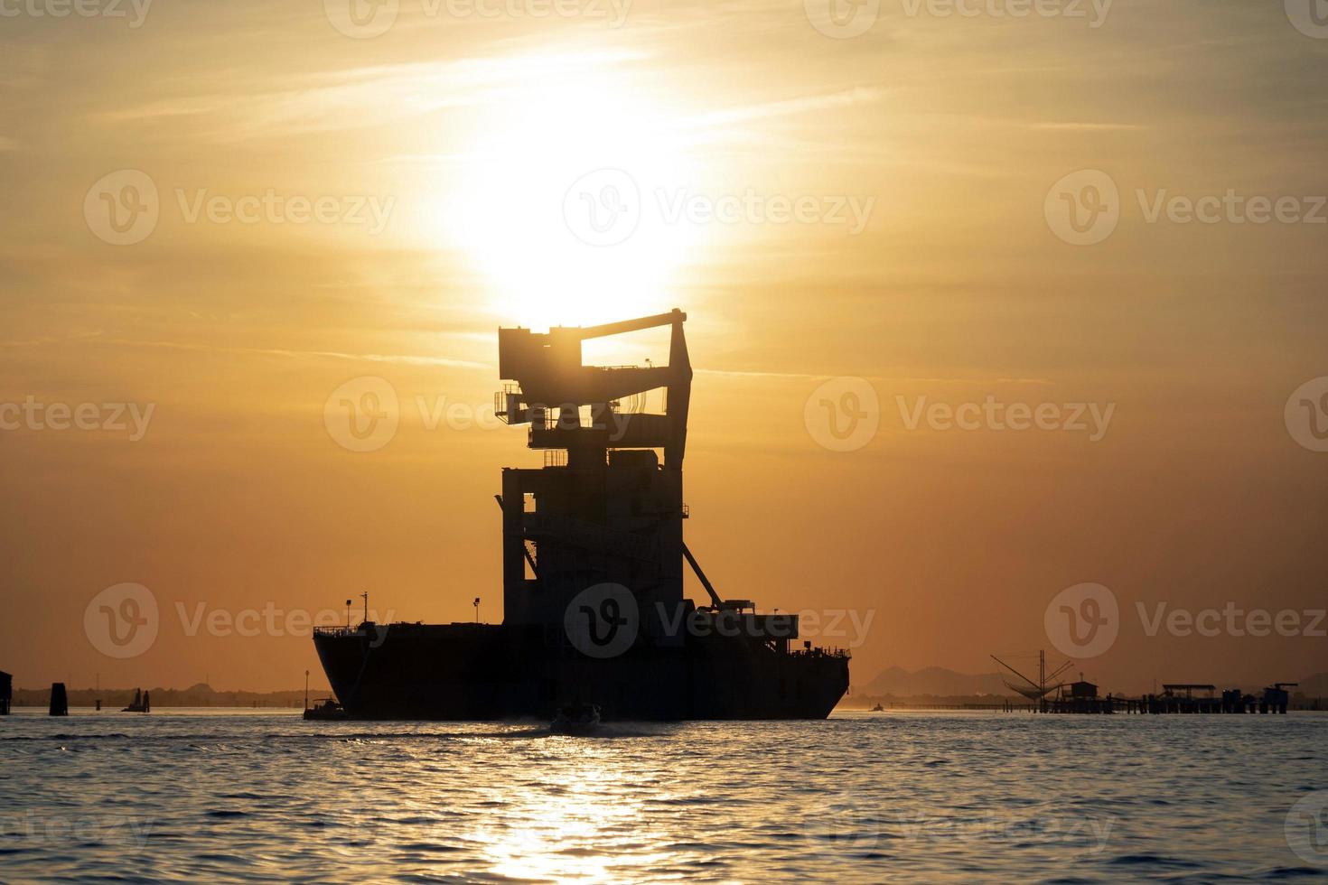 grain silos descharghing ship at Sunset in Venice lagoon chioggia harbor photo