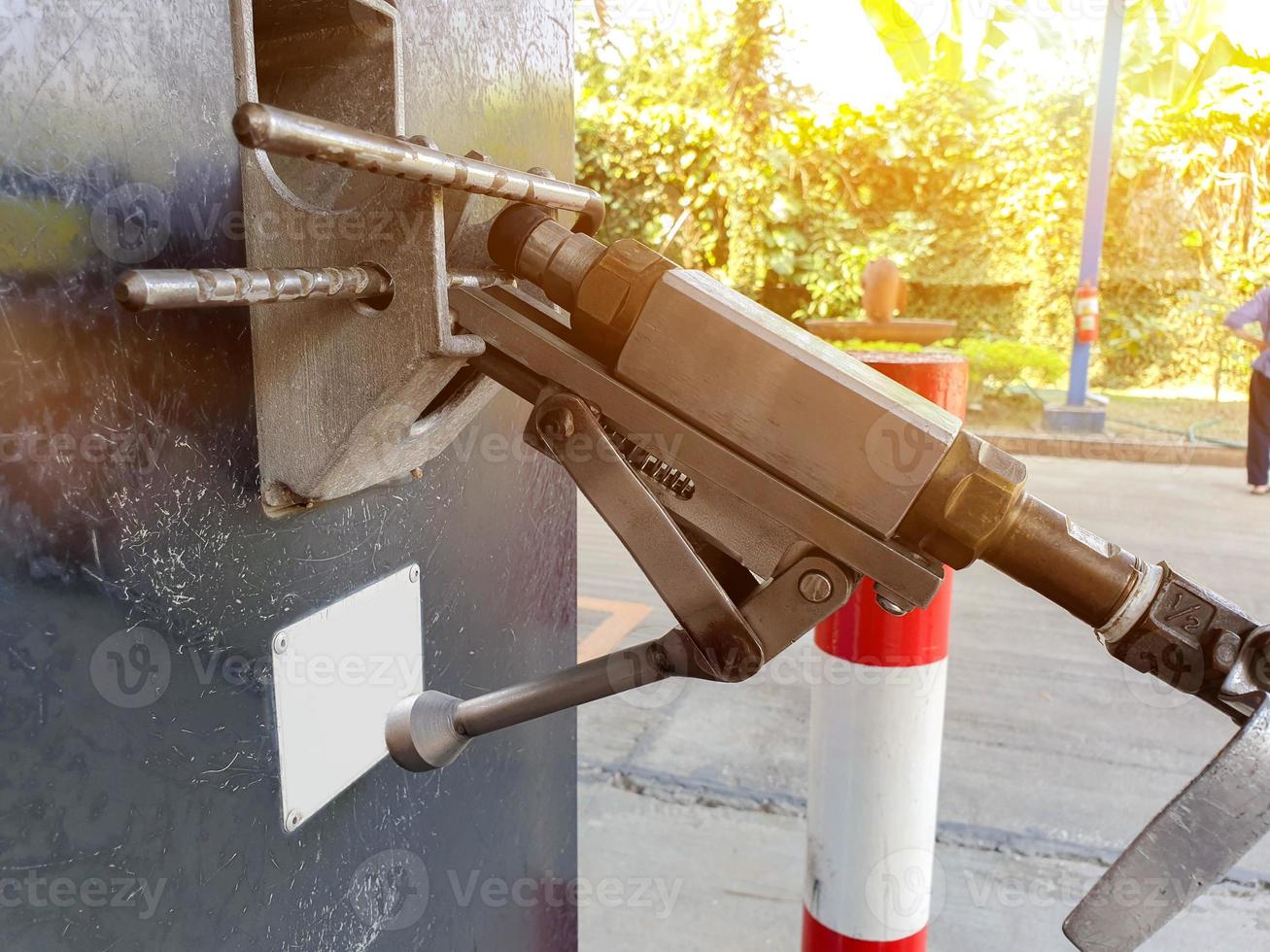 Dispensador de gas de primer plano para automóvil en la gasolinera en borroso con fondo de bengala solar. foto