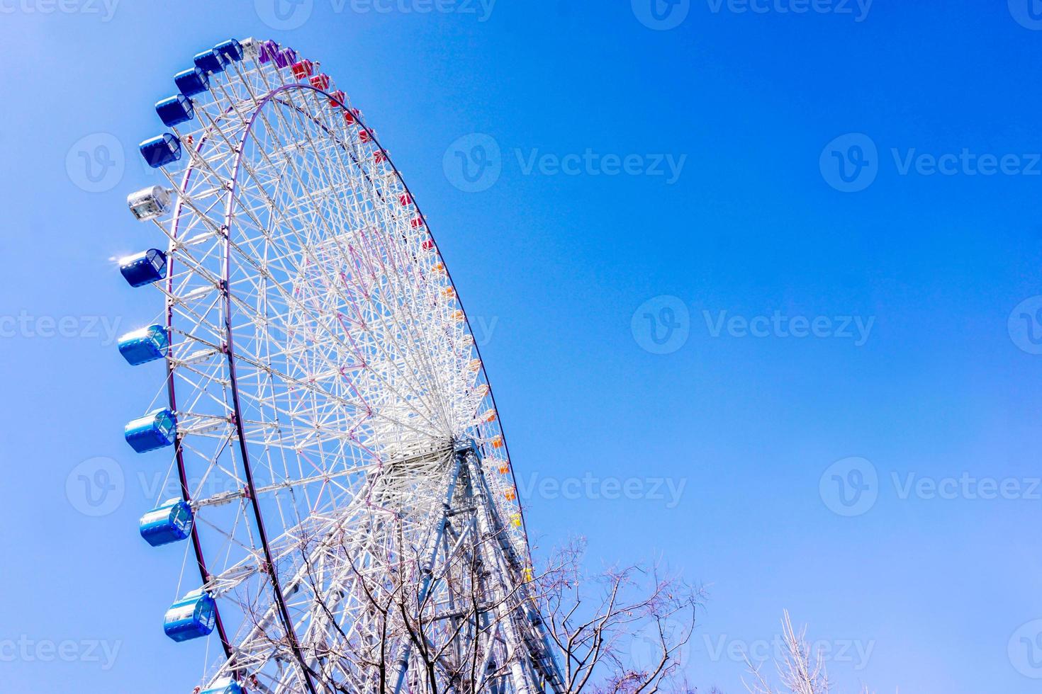 Closeup and crop Tempozan Giant Ferris Wheel on bright blue sky background with space for texts. photo