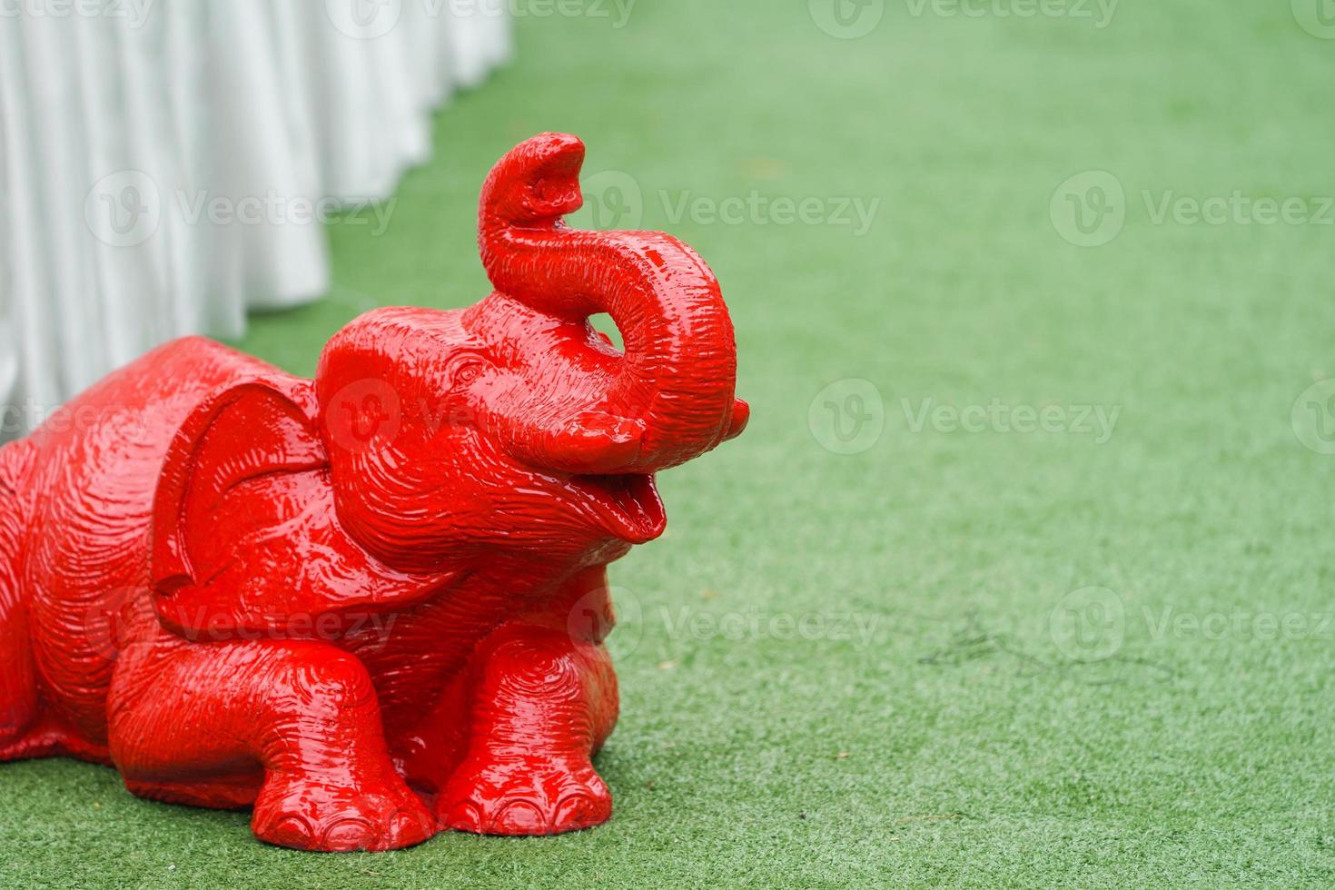 la figura de la estatua del elefante asiático se sienta y se acuesta en el césped verde foto