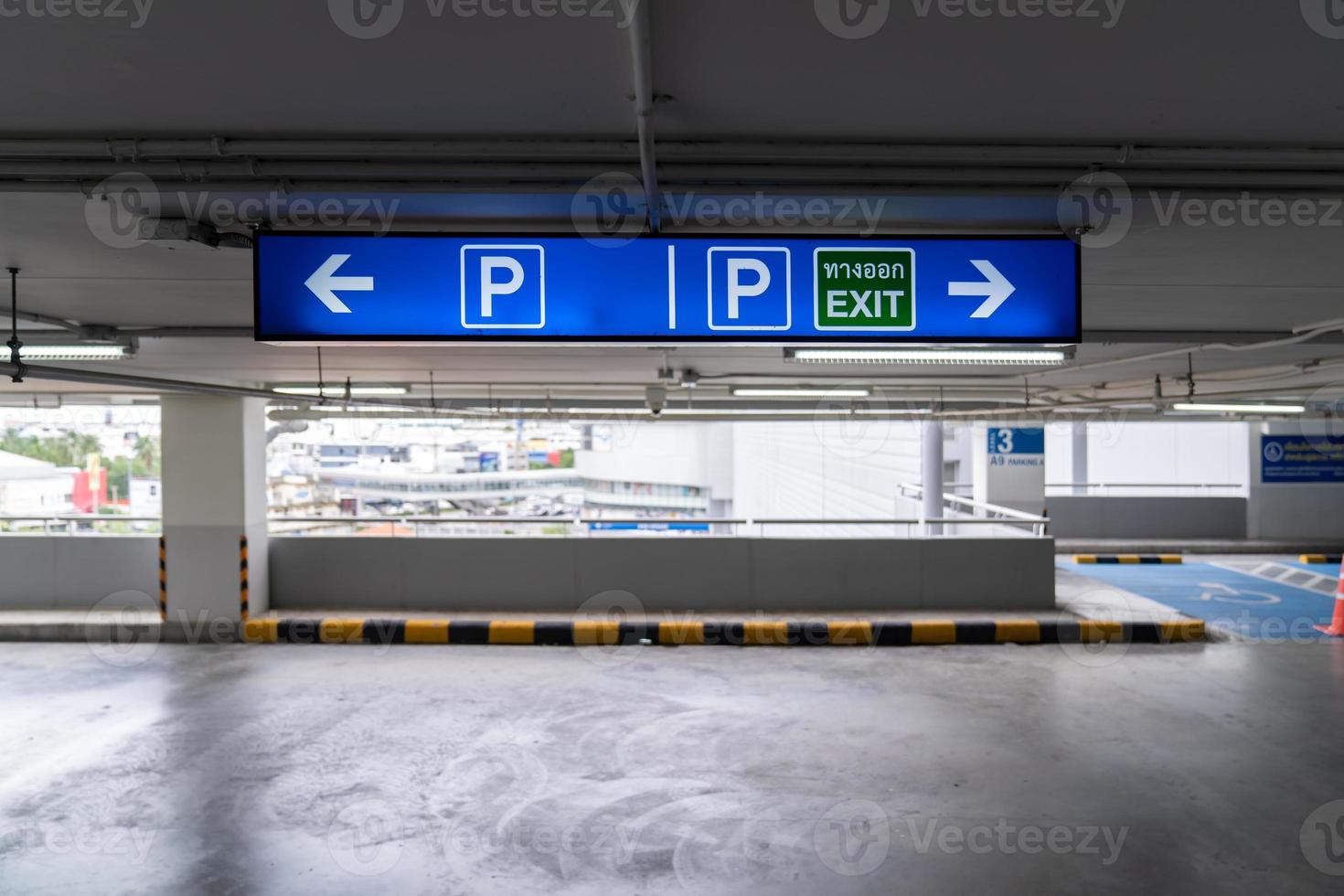 Signage Lightingbox in the indoor carparking, tell driver which way is parking lot or exit. Thai Language in green square on lightinbox means EXIT. photo