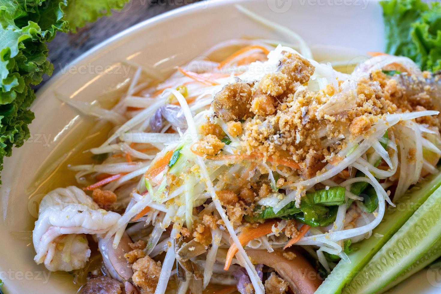 Somtum, Papaya spicy salad on white dish, the famous Thai traditional food. photo
