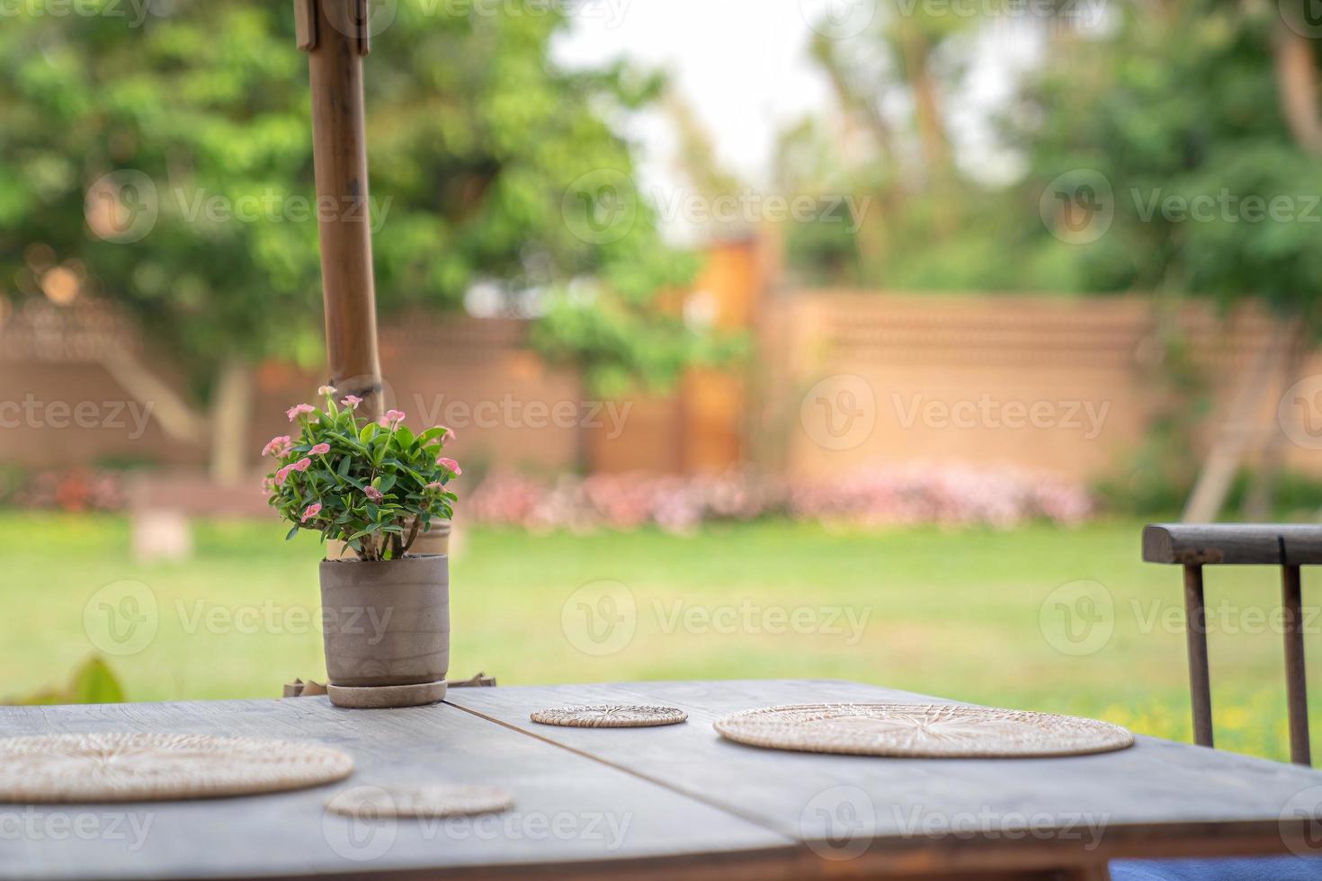 Thailand Northern traditional modern combination wood table and chair set with wicker plate on it in the garden blur background photo