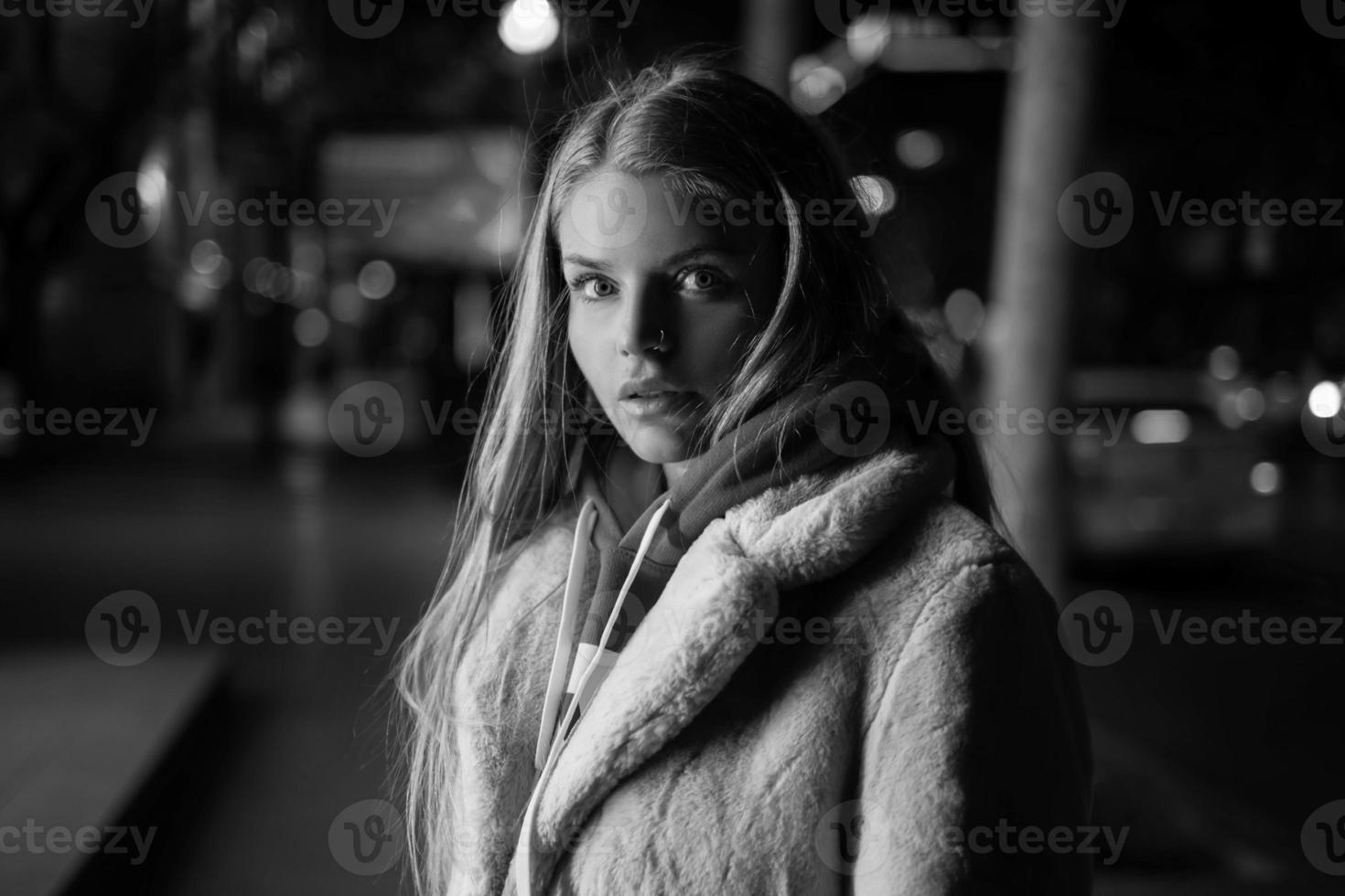 retrato en blanco y negro de una niña en el contexto de una ciudad nocturna foto