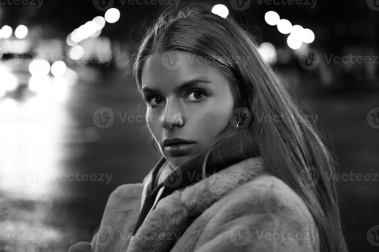 retrato en blanco y negro de una niña en el contexto de una ciudad nocturna foto