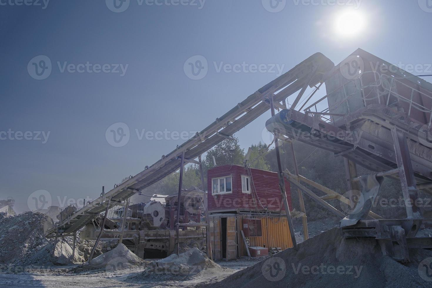 conveyor belt at the quarry for the extraction and production of crushed stone on a summer day photo