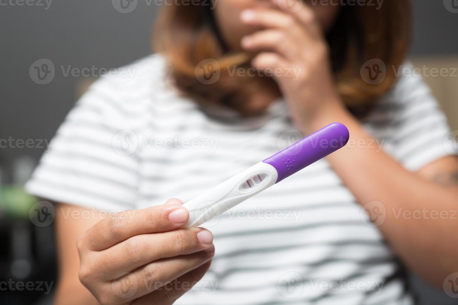 mujer joven mirando espectáculo en la mano para comprobar el kit de prueba de embarazo. ella está revisando su examen de embarazo. éxito felicidades nueva mamá. foto