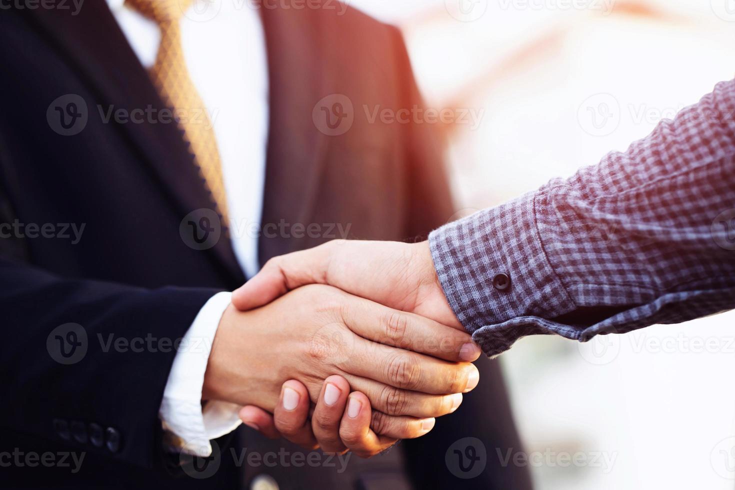 El primer plano de un apretón de manos de un hombre de negocios entre dos colegas saluda, representa que la amistad es buena, éxito, felicitaciones. al aire libre del fondo del edificio. copiar dejar espacio para el texto. foto