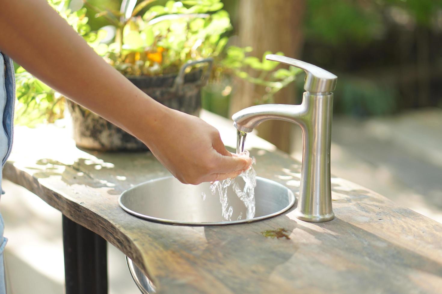 manos femeninas abren agua para lavarse las manos foto