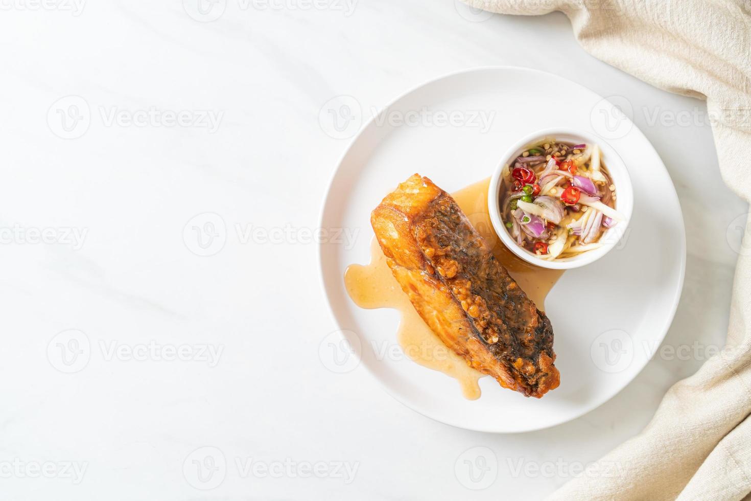 fried snapper fish with fish sauce and spicy salad photo