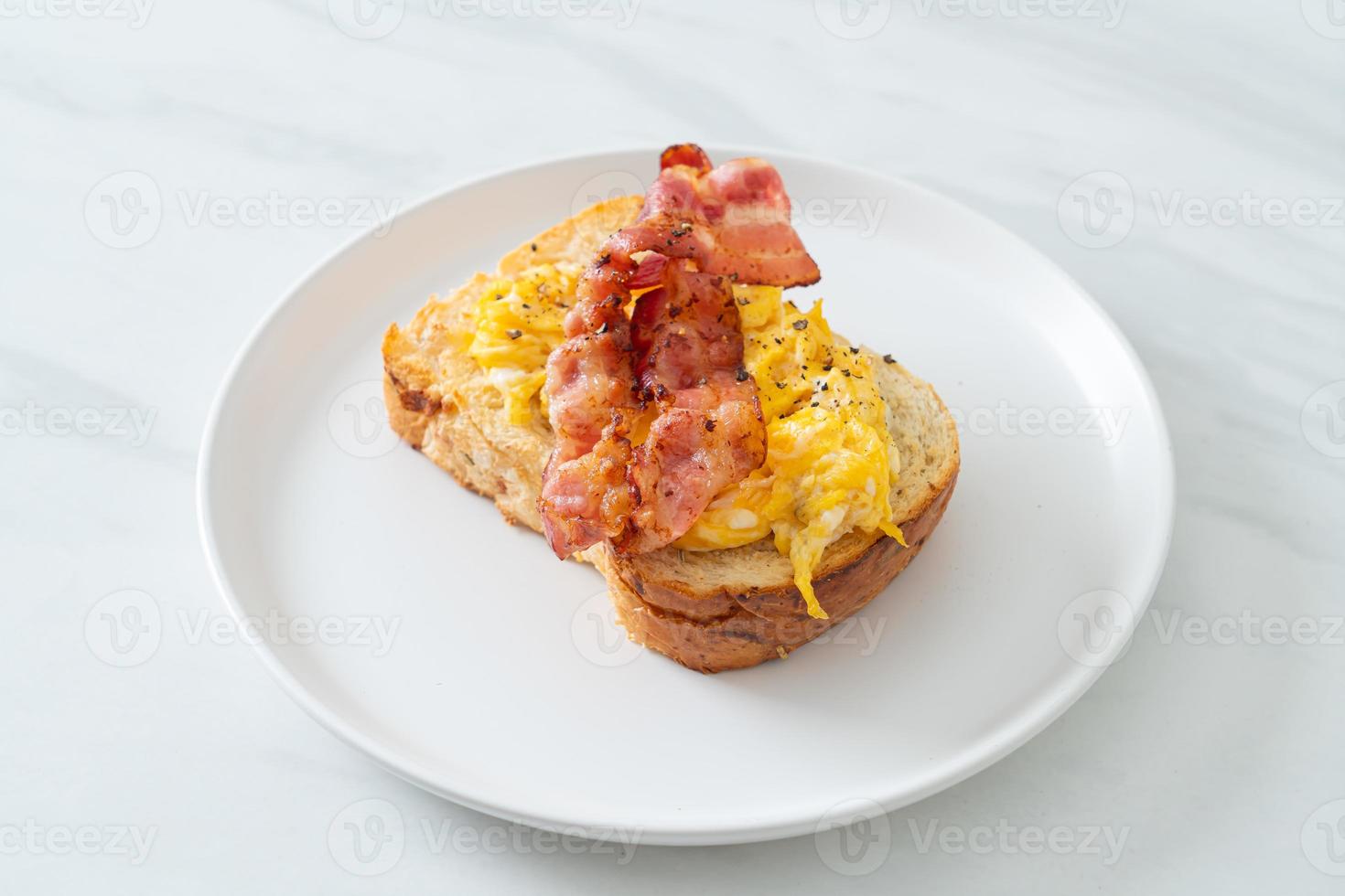 tostada de pan con huevos revueltos y tocino foto