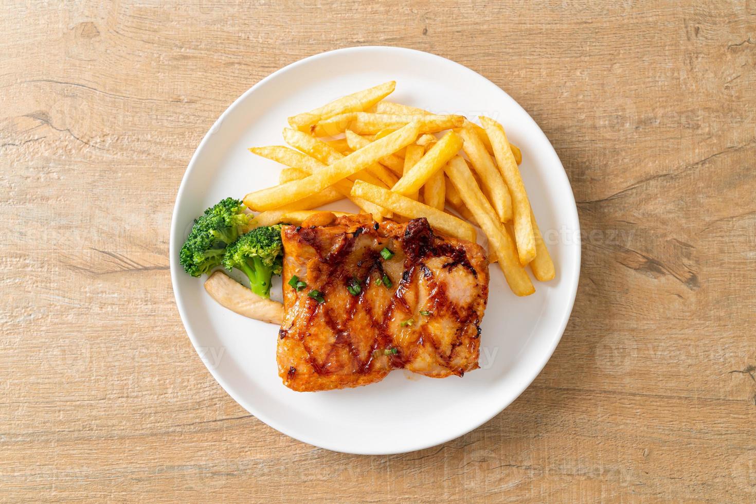 grilled chicken steak with potato chips or french fries photo