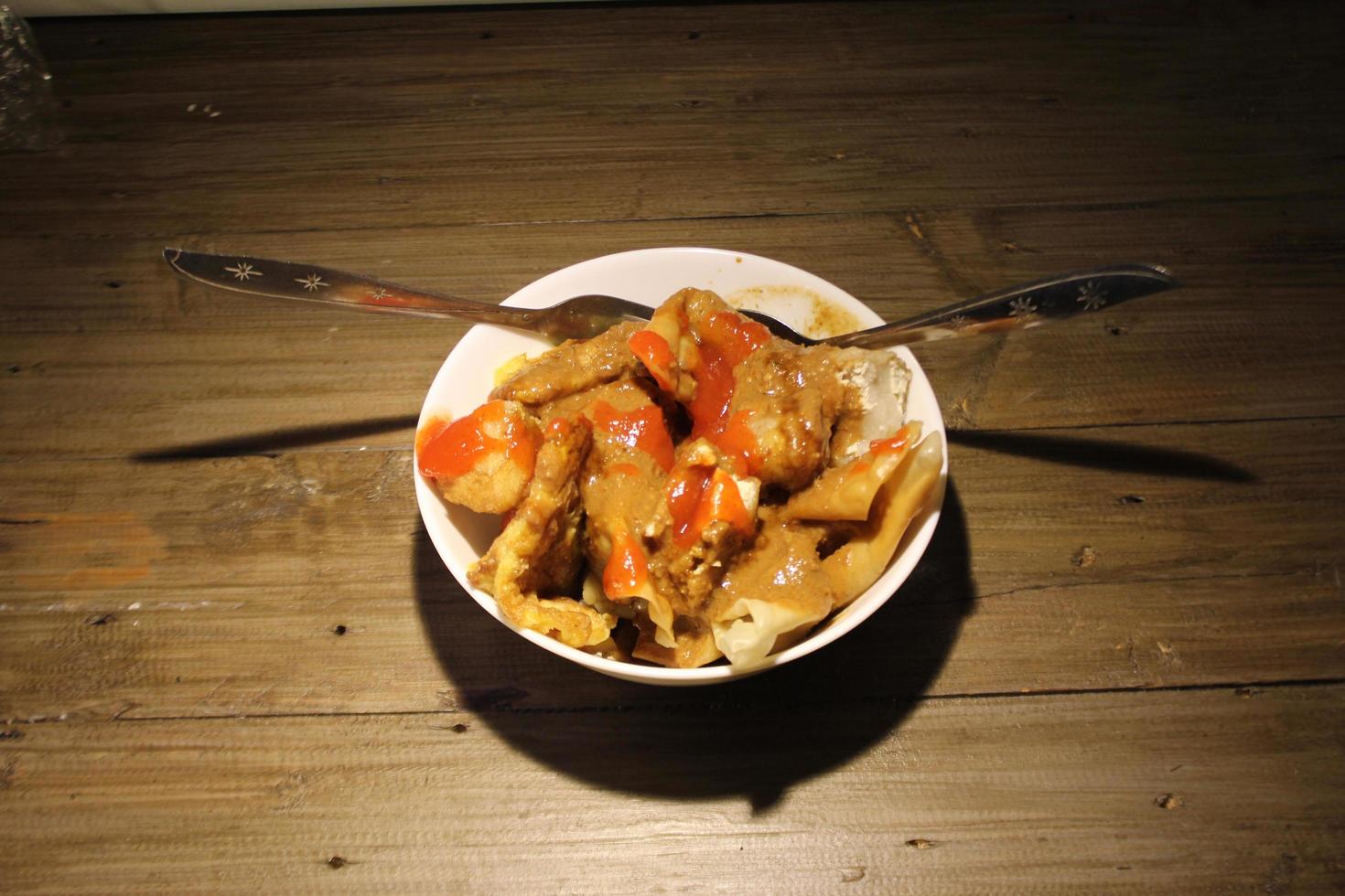 fried batagor on a white bowl. batagor is an Indonesian snack food, usually enjoyed with the addition of peanut sauce, soy sauce and chili sauce. photo