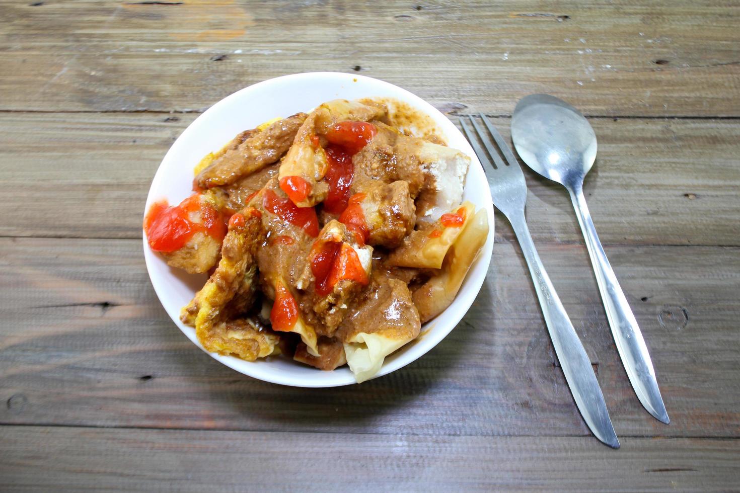 fried batagor on a white bowl. batagor is an Indonesian snack food, usually enjoyed with the addition of peanut sauce, soy sauce and chili sauce. photo