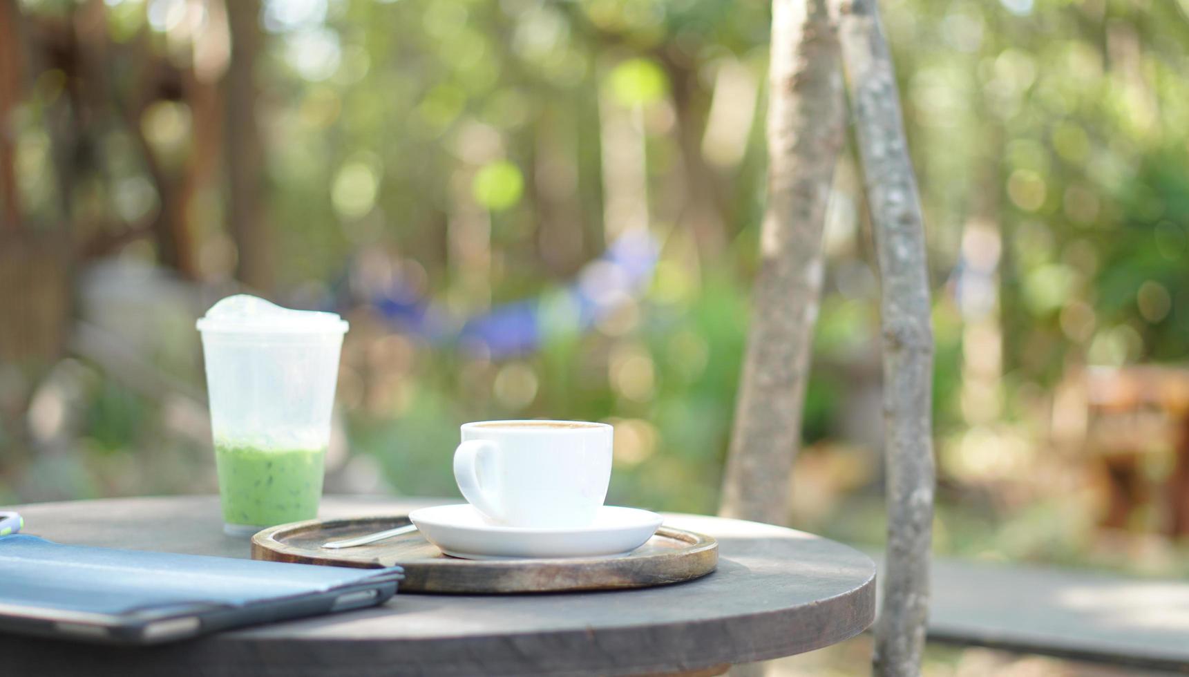 White hot coffee cup and green tea mug on wooden table photo