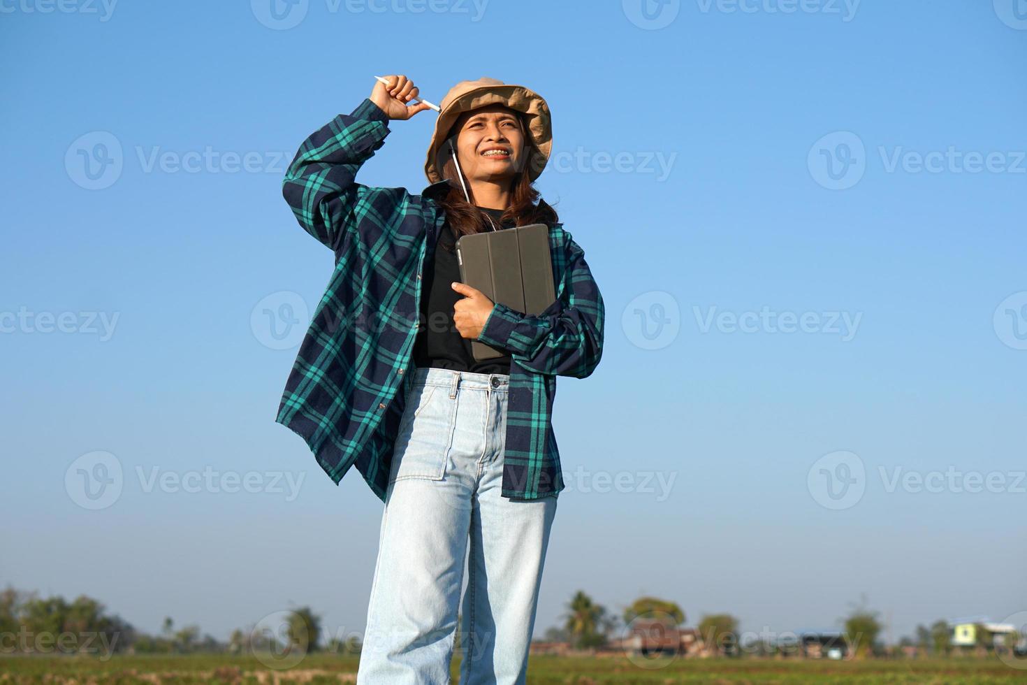 Asian female farmers use computers to analyze the growth of rice plants. photo