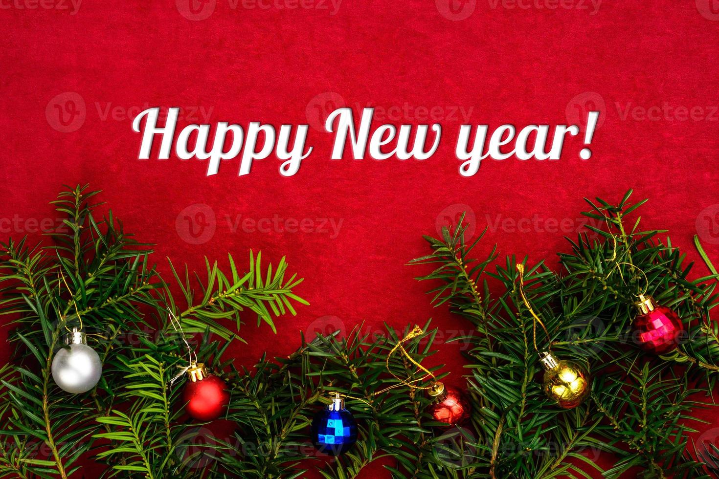 Inscription Happy New Year on red background with Christmas tree and balls with top view photo