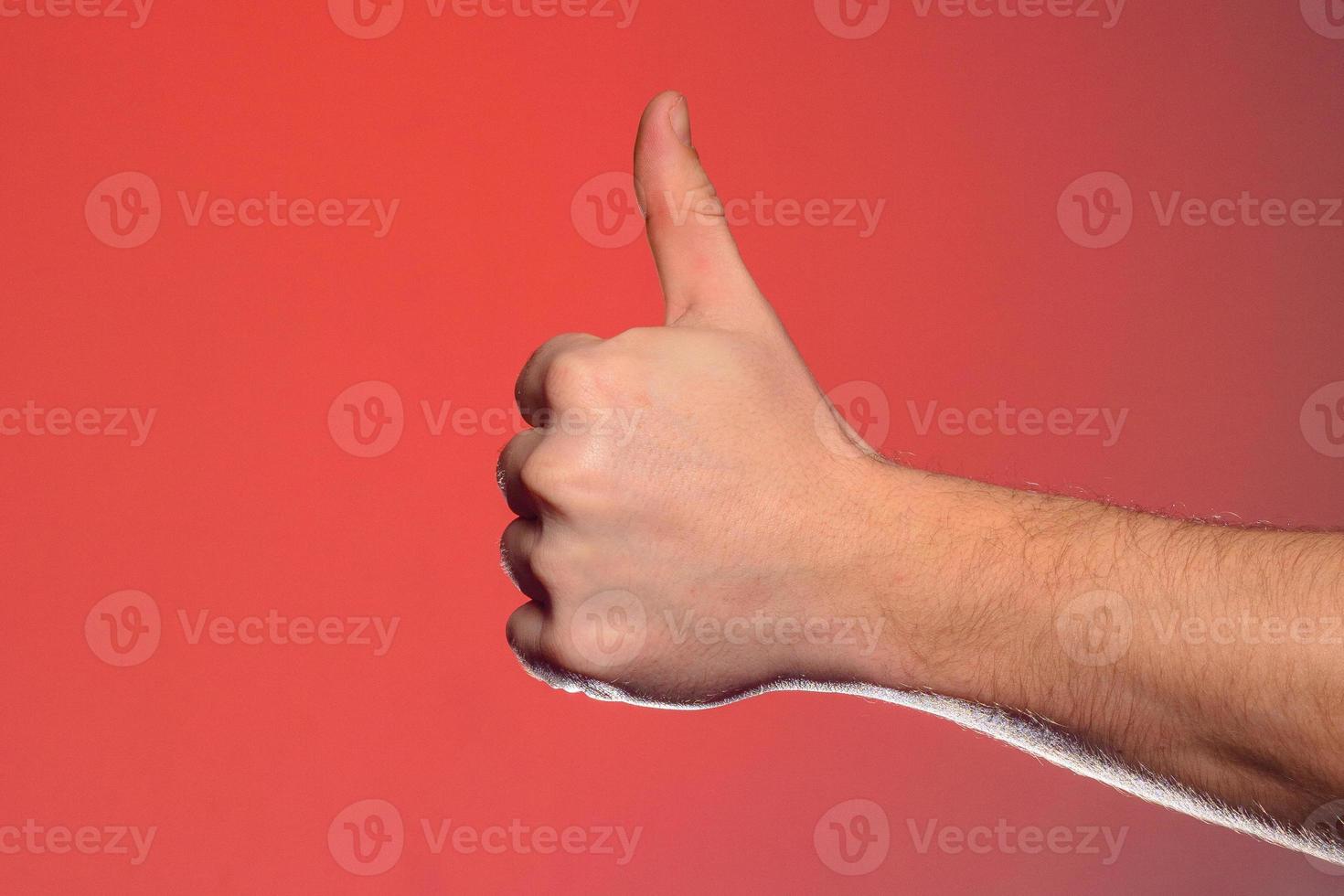 Close-up of a hand with a fingernail up of an isolated on a red background photo