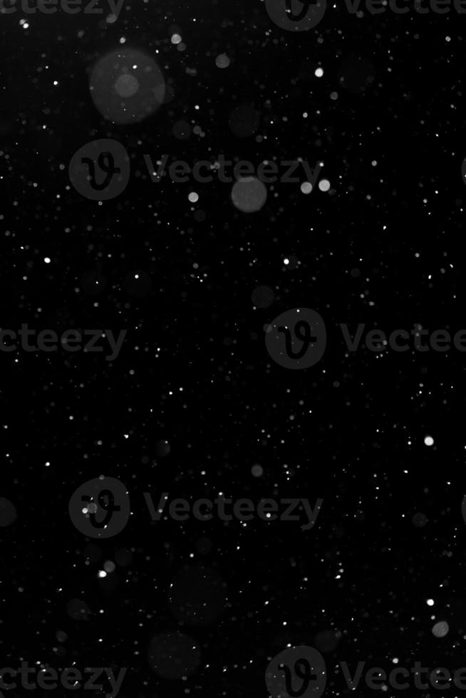 Bokeh white snow on a black night background photo