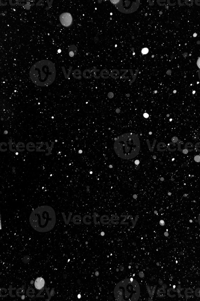 Bokeh white snow on a black night background photo