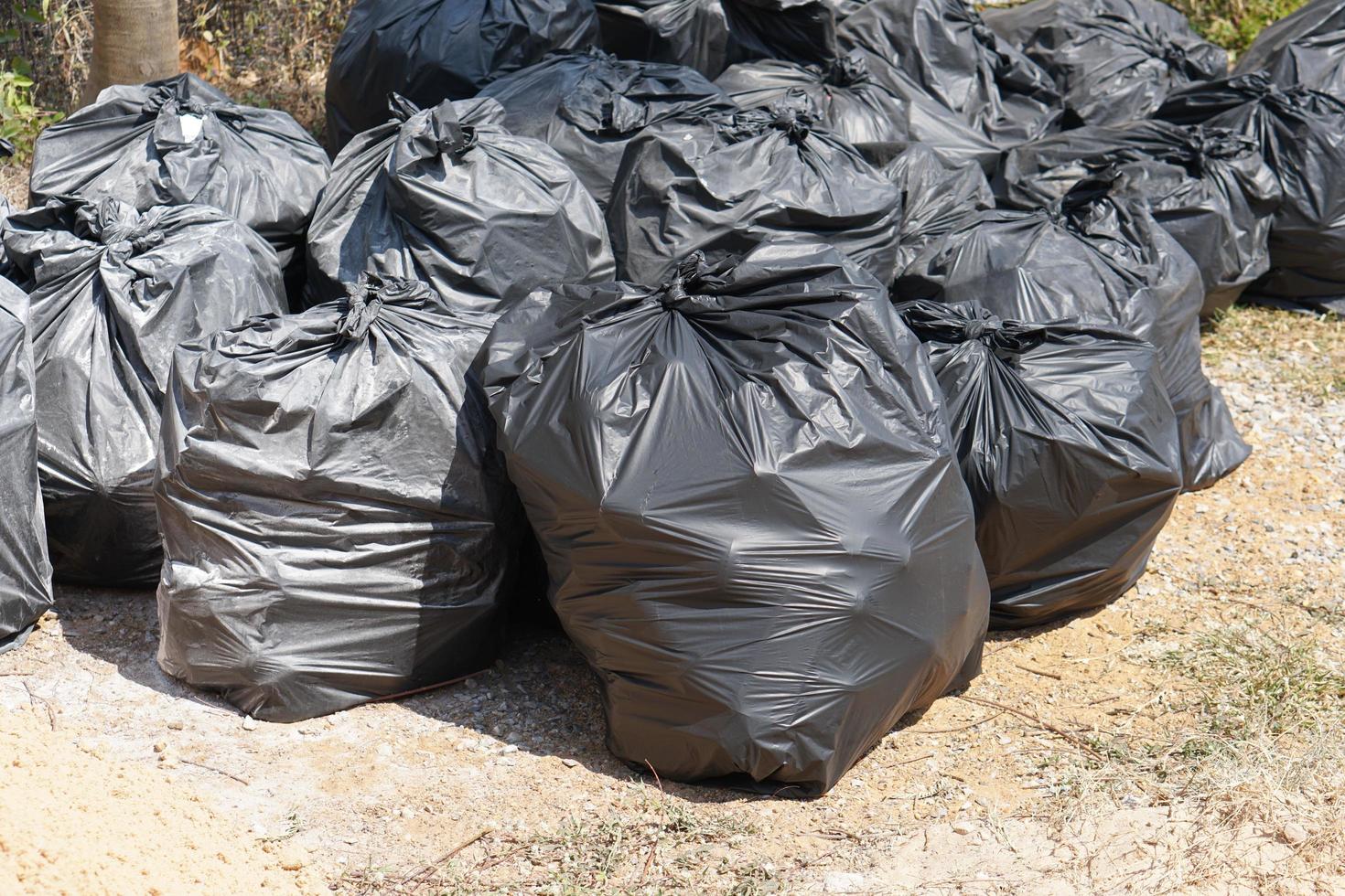 A large black garbage bag on the side of the road. photo