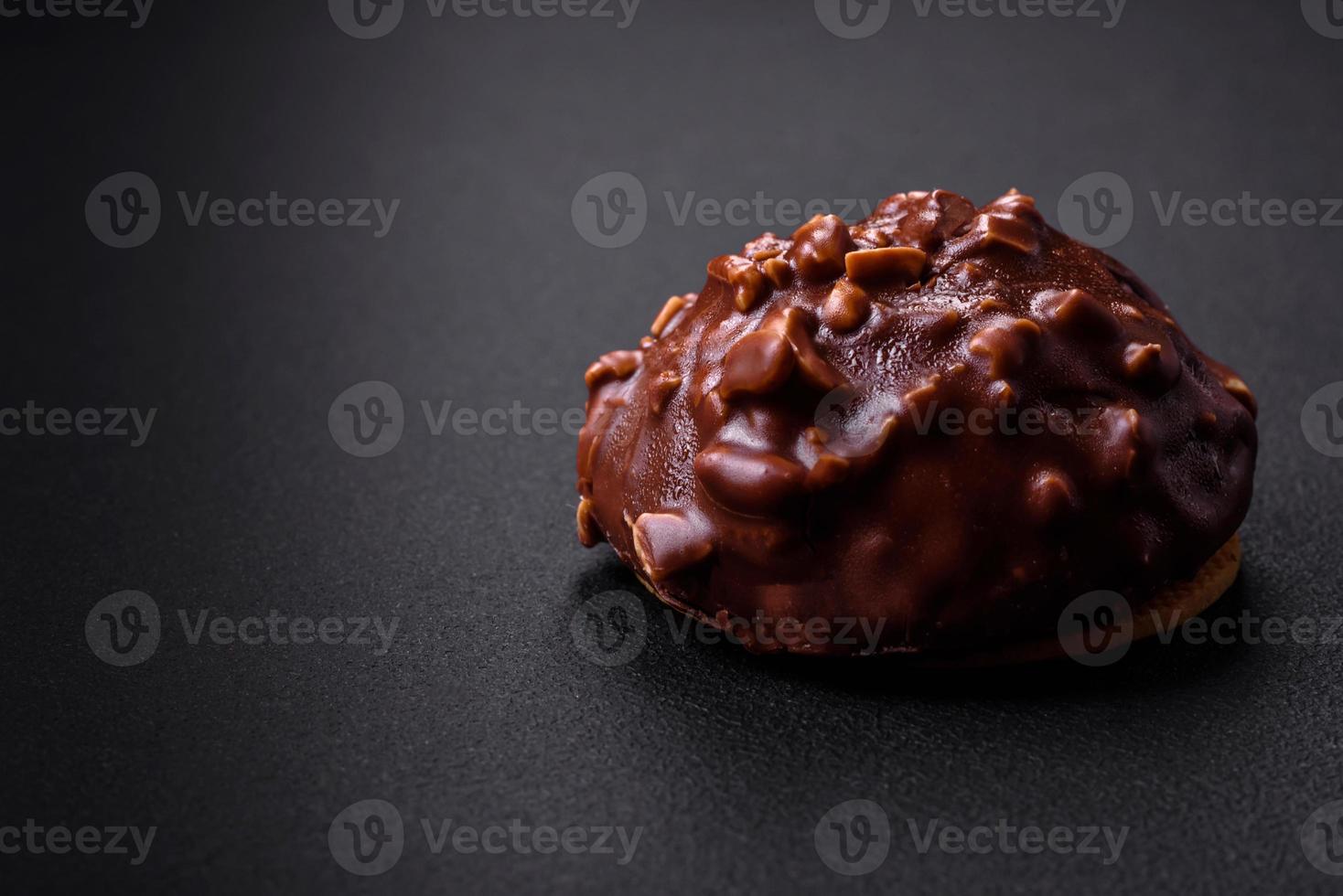 Delicious chocolate tart with nuts on a black ceramic plate photo