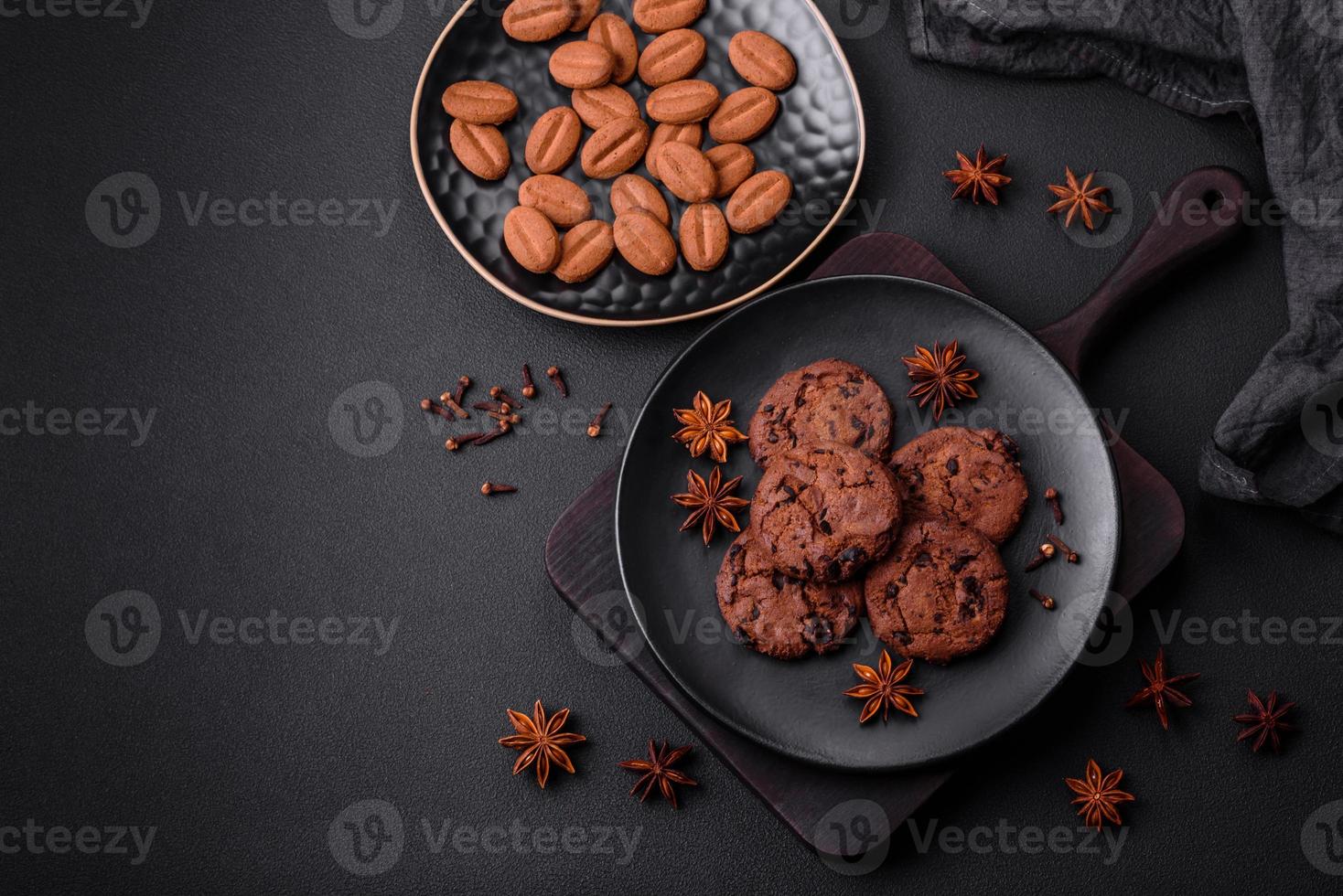 Delicious chocolate cookies with nuts on a black ceramic plate photo