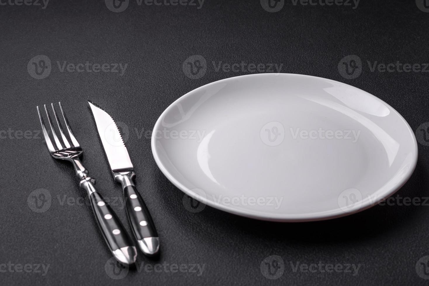 Empty ceramic round plate on dark textured concrete background photo